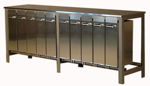 A photograph of a large steel table, with one row of ten tall swing-out drawers facing the viewer